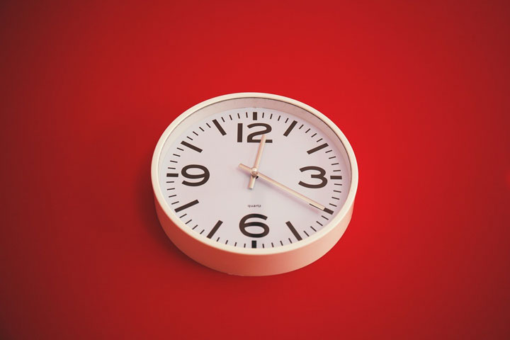 ساعت سفید روی سطح قرمز
