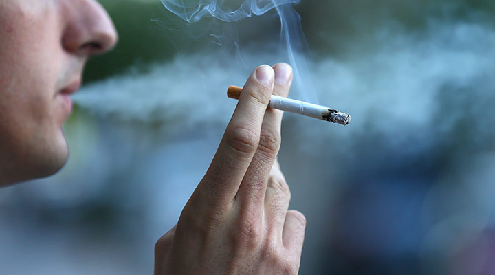 دست و سیگاری بین انگشتان - دود سیگار با درمان سرفه مغایرت دارد