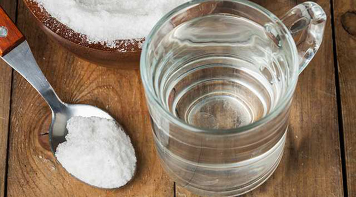 لیوان آب و یک قاشق نمک - قرقره این محلول به درمان سرفه کمک می‌کند